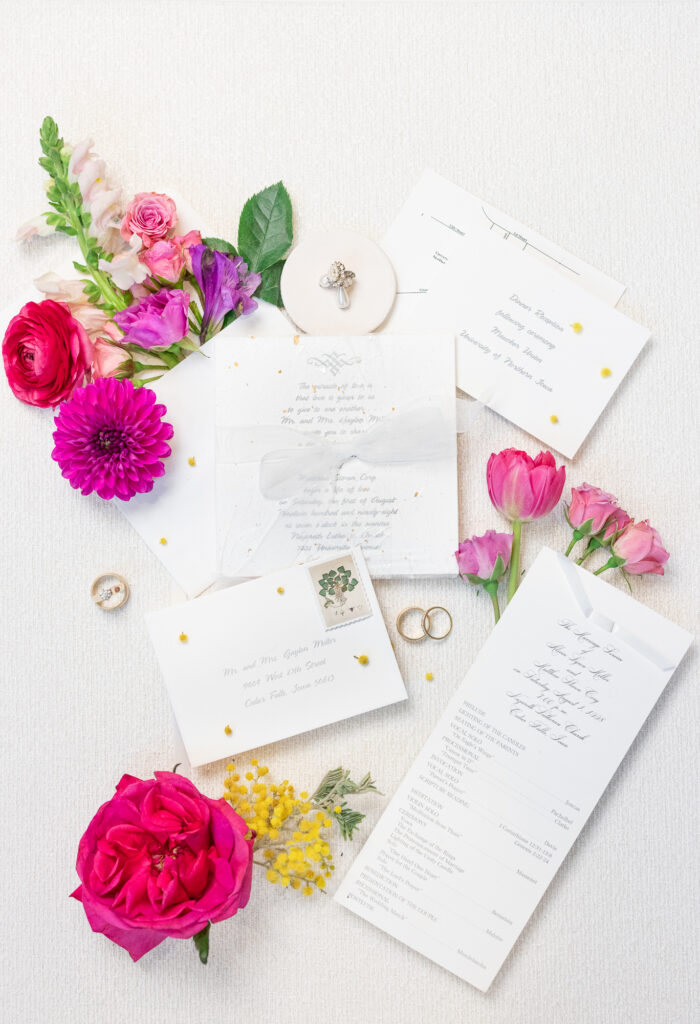neutral wedding invitation suite with vibrant florals and jewelry