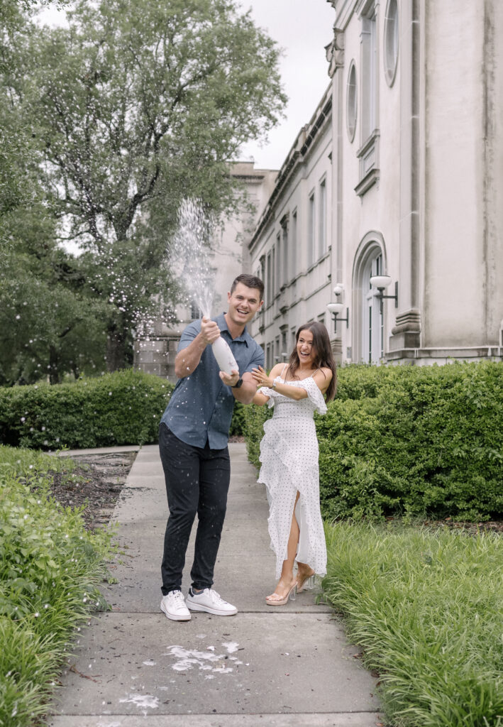 Engaged Couple Popping Champagne in downtown Charleston