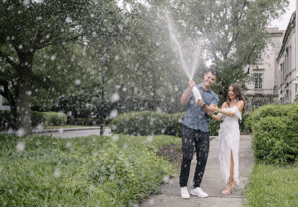 Engaged Couple Popping Champagne in downtown Charleston